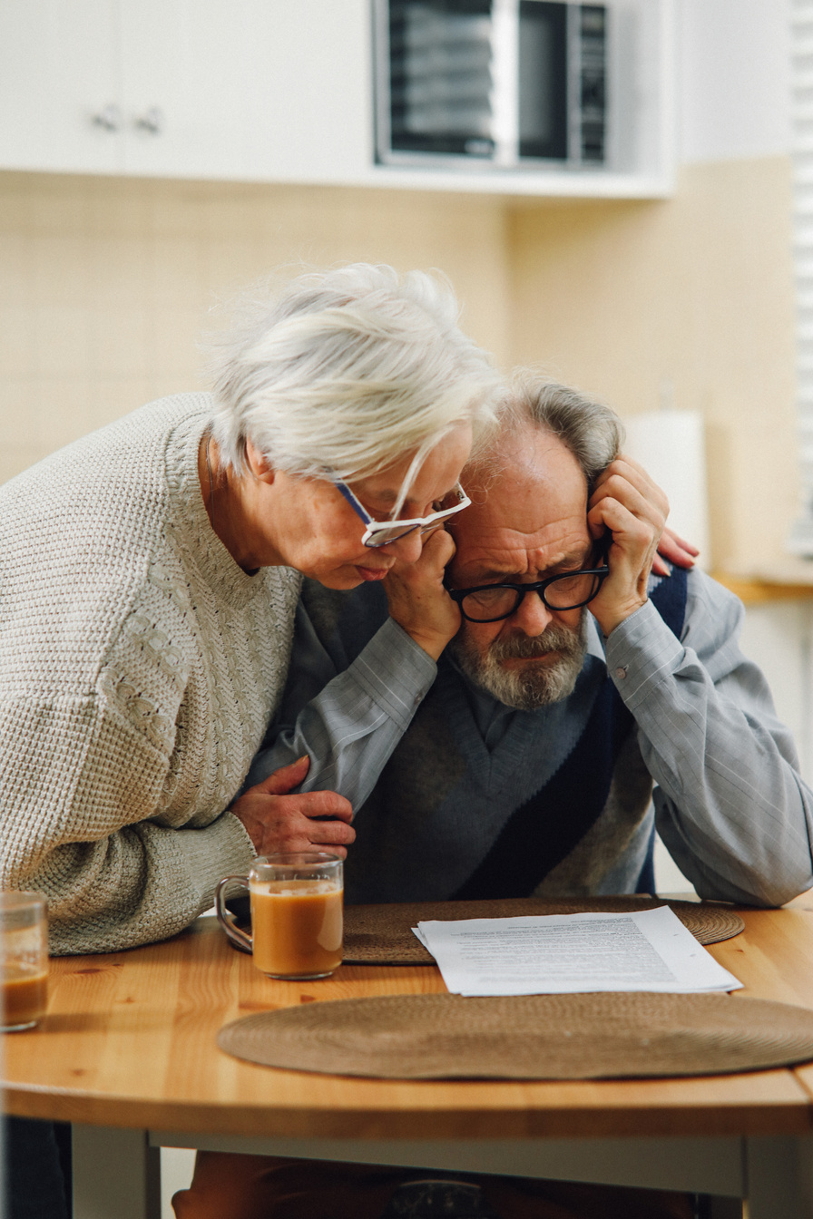 Worried Senior Couple Looking at Documents on a Table 